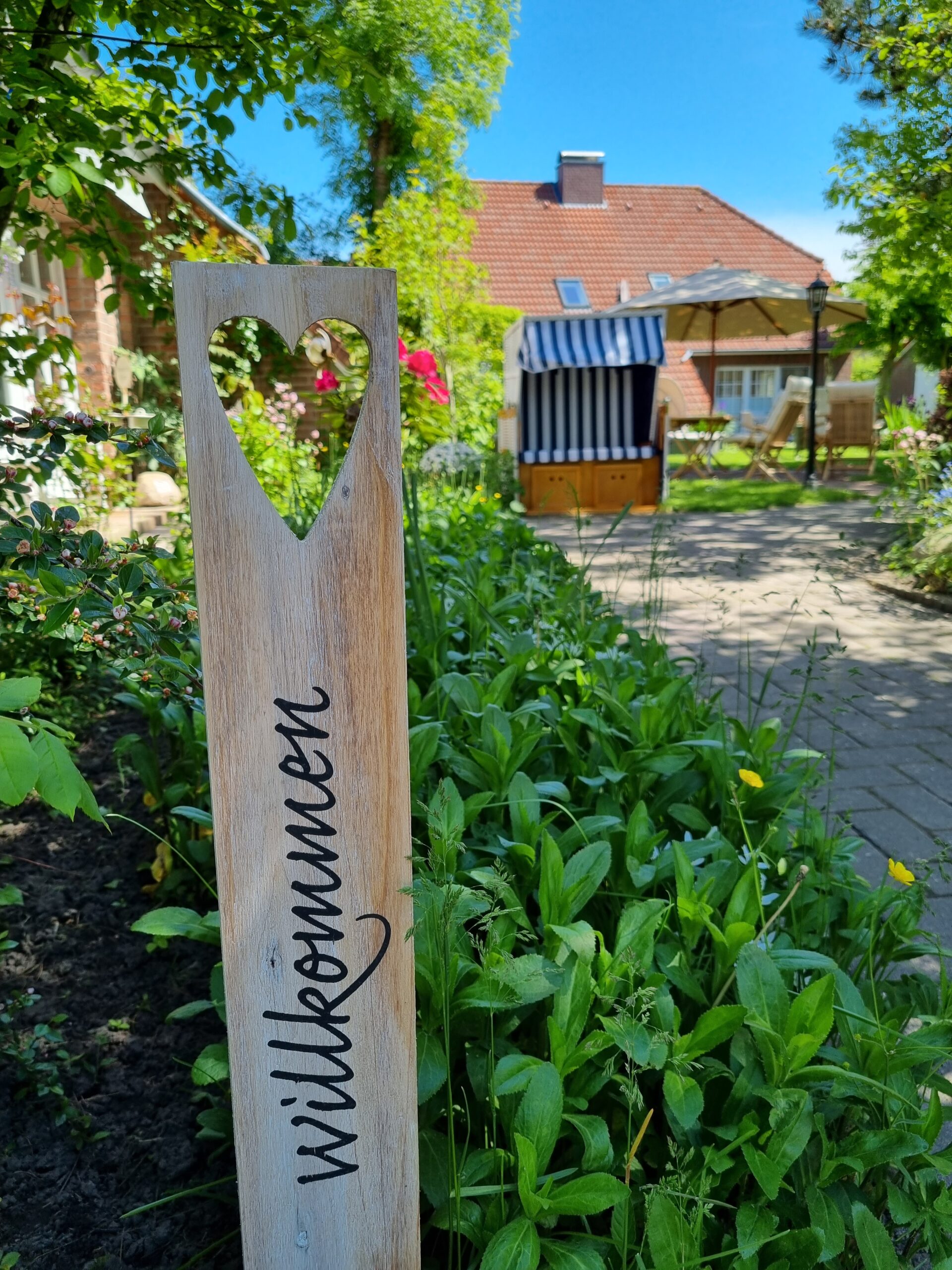 Dekorierter Garten mit Holzsteele und Strandkorb