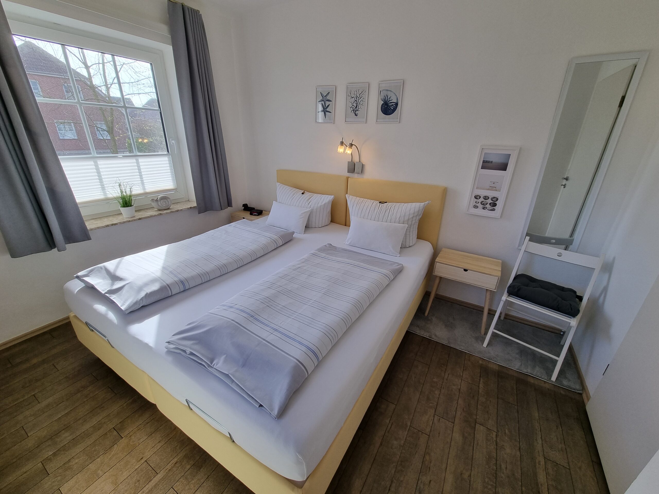 Separater Schlafbereich mit Doppelbett im Hotel Friesenhuus mit Blick auf ein Fenster