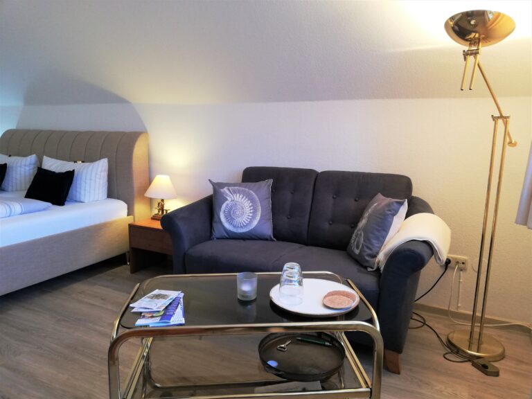Sofa und Doppelbett im Hotelzimmer des Hotel Friesenhuus