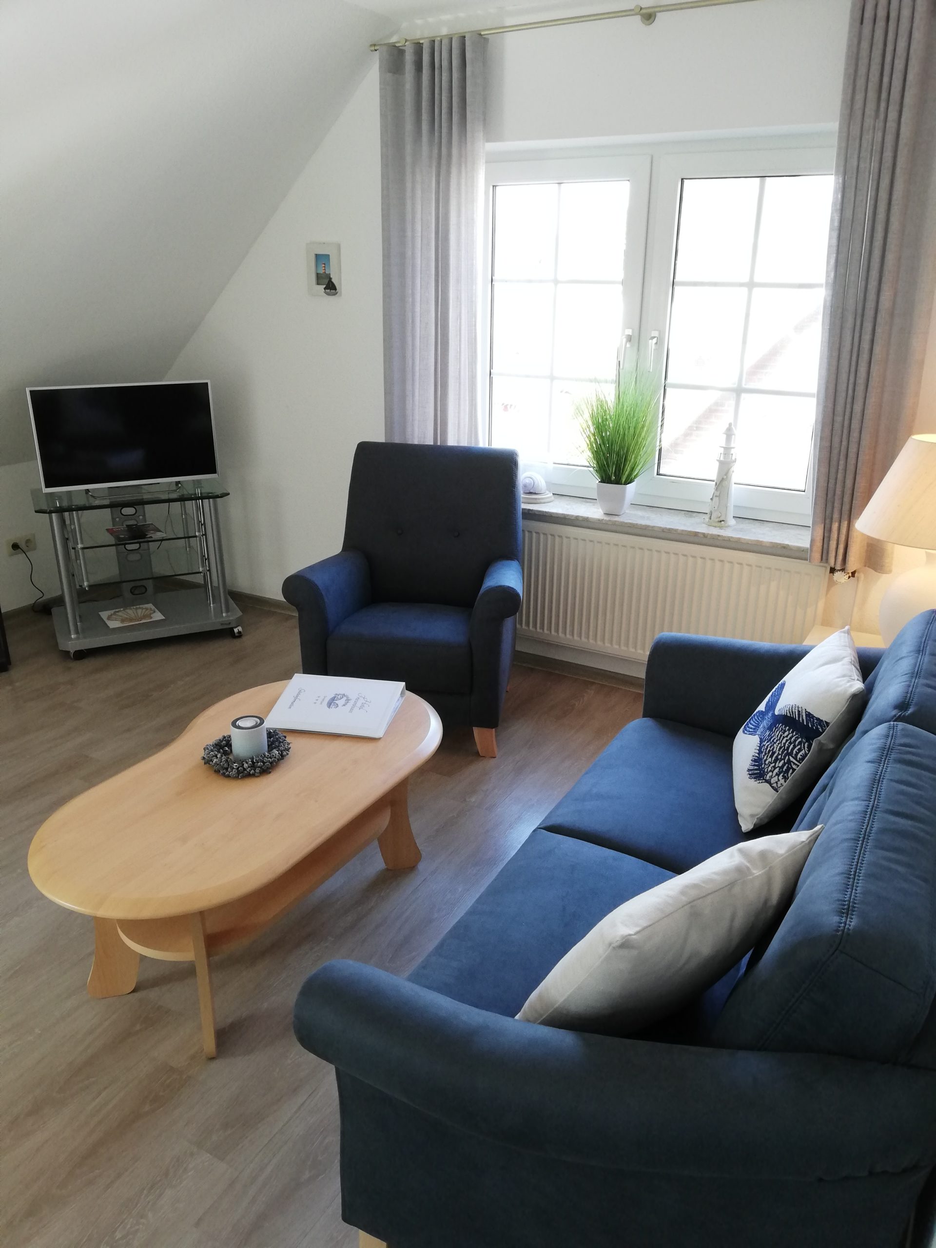 Wohnbereich mit Sessel, Doppelsofa und Fernseher