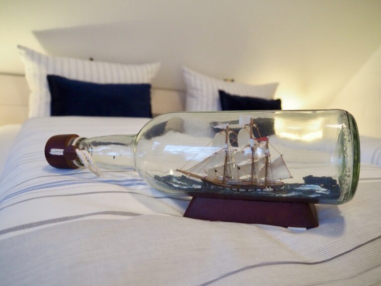 Modell eines Segelschiffs als Buddelschiff auf einem Doppelbett